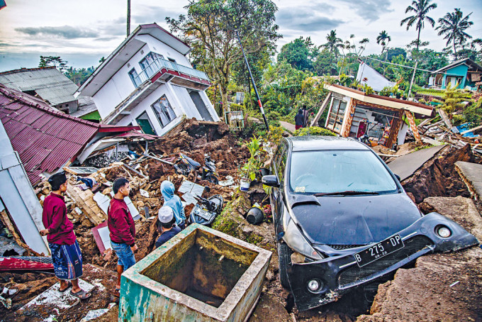 展玉災區的村民，在地震損毀的房屋中找尋有用物品。