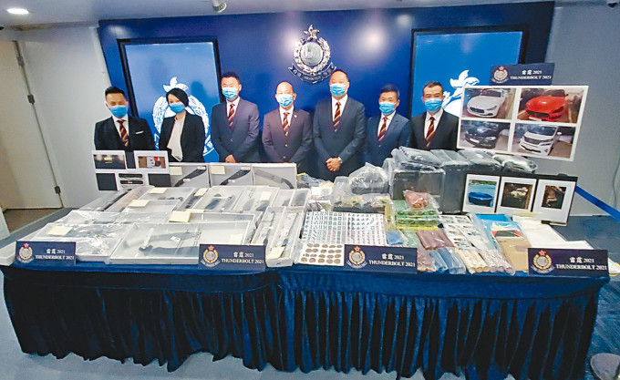 「Ｏ记」总警司黄维（中）与其他总区警官交代「雷霆2021」成果，并展示搜获的大批武器及证物。