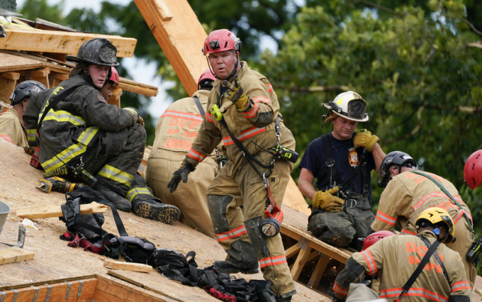 消防隊員將現場的瓦礫救援受困工人。AP圖片