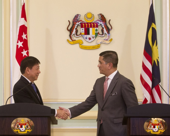 马来西亚经济事务部长阿兹敏(右)与新加坡交通部长许文远在行政中心布特拉加亚 (左)。AP