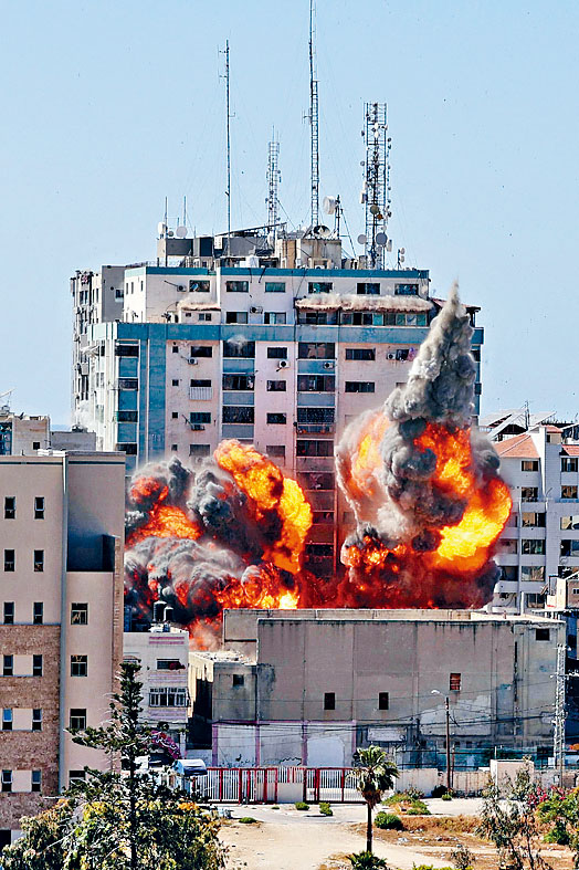 ■加沙市的媒體大樓遭以軍戰機發射導彈摧毀，冒出濃煙。