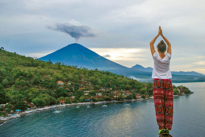 一名游客在峇里岛，面向阿贡火山留影。