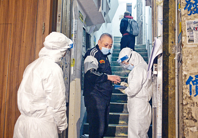 油麻地东安街与碧街「受限区」解封后，纪律部队人员驻守大厦出入口，检查住户验毒证明。