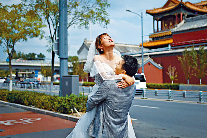 ■內地已經連續二十八日沒有本土病例。圖為一對新人北京街頭拍攝婚紗相。