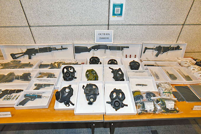 ■警方展示搜获的仿制枪械及防毒面罩等物品。