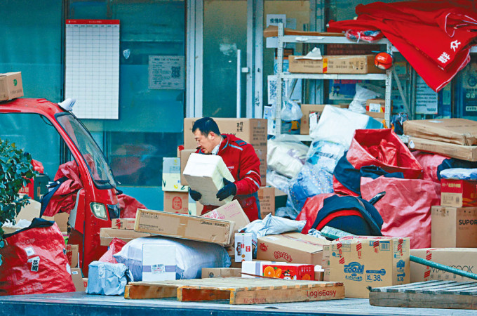 北京快遞員，正在整理大量的積壓包裹。