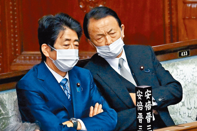 安倍晉三昨日在下議院全體會議上與自民黨副總裁麻生太郎交談。