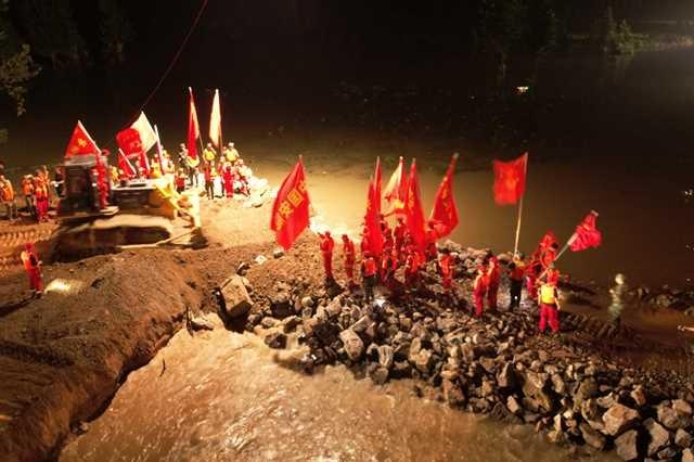解放军、武警部队官兵及中国安能集团救援人员共同庆祝河南鹤壁卫河决口合龙成功。中国安能