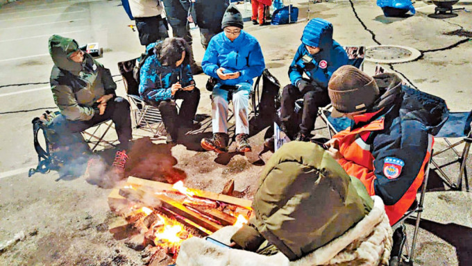 特区救援队在严寒天气下生火取暖，并获国家救援队提供热食保持体温。