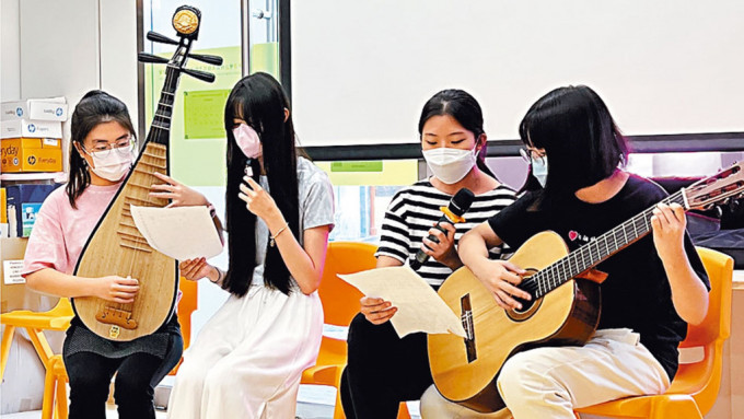 就讀中四的小領袖何希婷（左一）帶領組員一起演奏樂器及唱歌予長者欣賞。