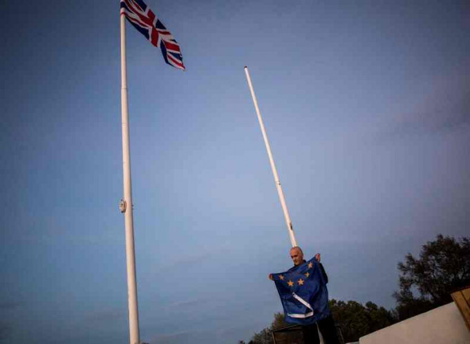 英國脫歐後直布羅陀一名工人將歐盟旗幟除下。AP