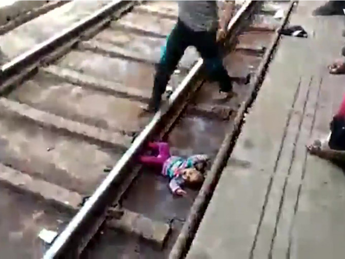 一名女婴跌落路轨，火车经过后奇迹幸存。（网图）