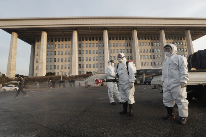韩国昨天关闭国会主楼和议员会馆，实施全面消毒防疫作业。AP