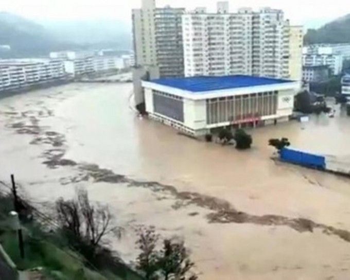绥德县城中，泥黄色洪水不断涌入街道。