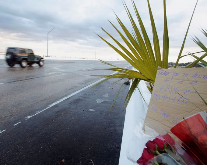  枪击案发生后有人在通往海军基地的路边放下鲜花。AP