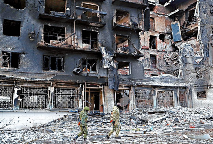 在烏東頓涅茨克伏爾諾華卡，親俄部隊人員走經一座嚴重受損的住宅大樓。 