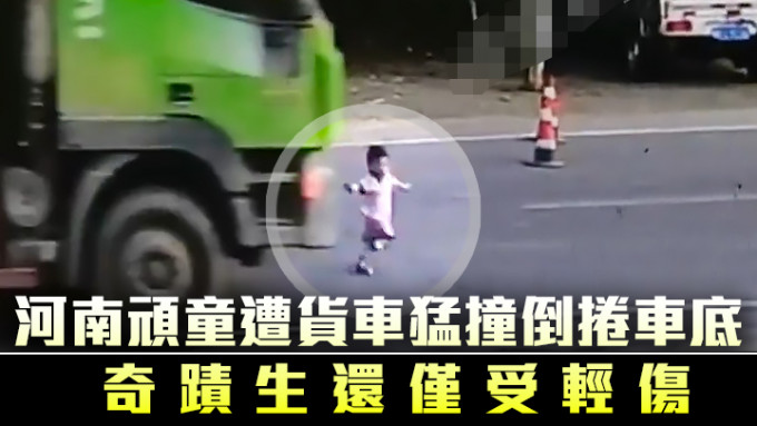 一名男童疑顽皮挣脱母亲的牵手，突然跑出马路，遭一架大型货车猛烈撞倒并卷入车底。(影片截图)