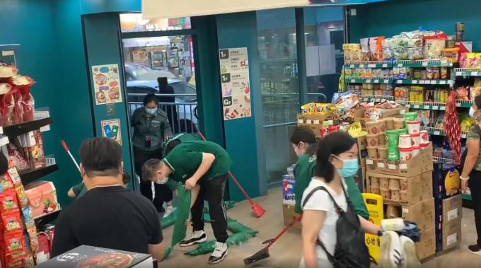 超市职员忙于清理积水。网民许小敏片段截图