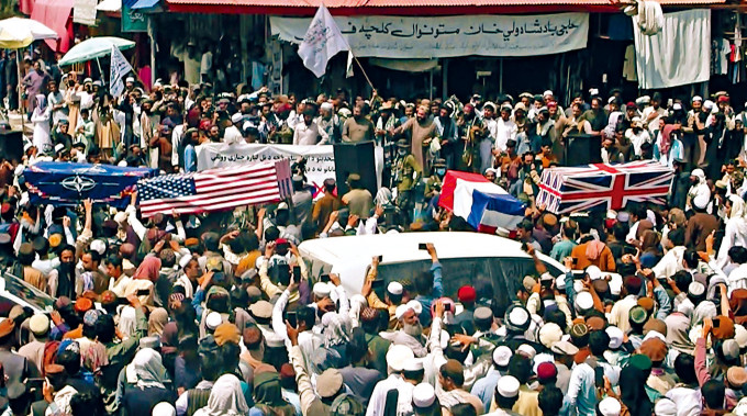 塔利班支持者周二在阿富汗霍斯特街头抬假棺材，为美国、英国和北约「送葬」。