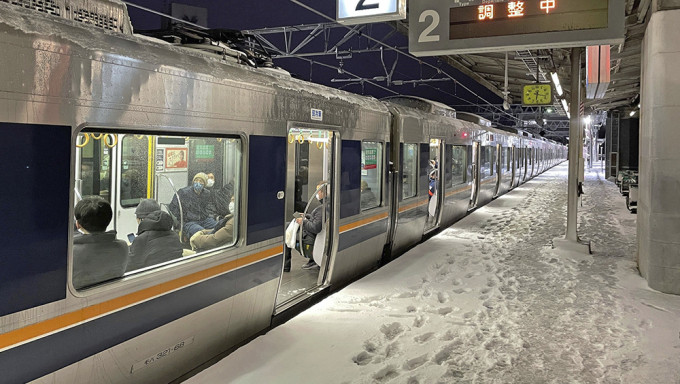 日本京都受到大雪影响，铁路列车25日停靠在西大路站暂停行驶。AP