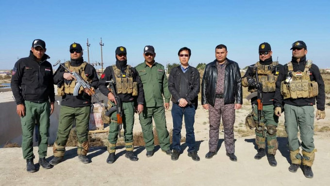 郑彼得（右四）与负责保护旅行团的伊拉克特种部队成员合照。 受访者提供