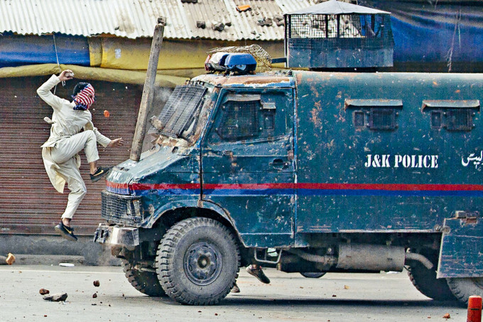 專題攝影獎照片之一：去年五月底印控克什米爾的示威者跳向警車的引擎蓋。