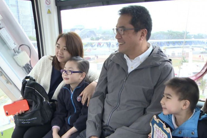 黄伟纶（右二）与学童和家长在摩天轮车厢合照留念。