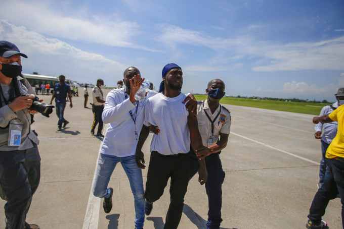 一名海地人在太子港机场被警员带走。美联社图片