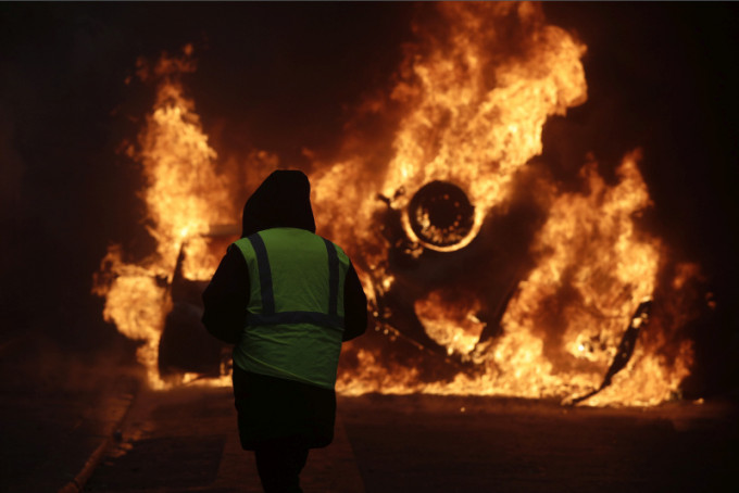 大批戴口罩的示威者手持鐵棍和斧頭在巴黎街頭騷亂，縱火燒毀10多輛車及建築物。AP