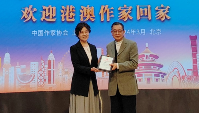 中國作家協會主席鐵凝向香港作家聯會會長潘耀明頒發紀念證書。 中通社