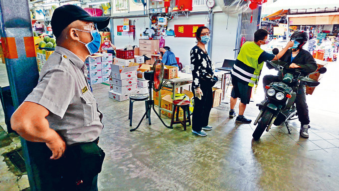 ■民眾進入台北菜市場，必須接受測溫，衞警全程監看。