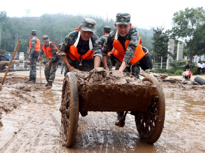 暴雨過後官兵到鞏義市小關鎮幫助清淤工作。新華社