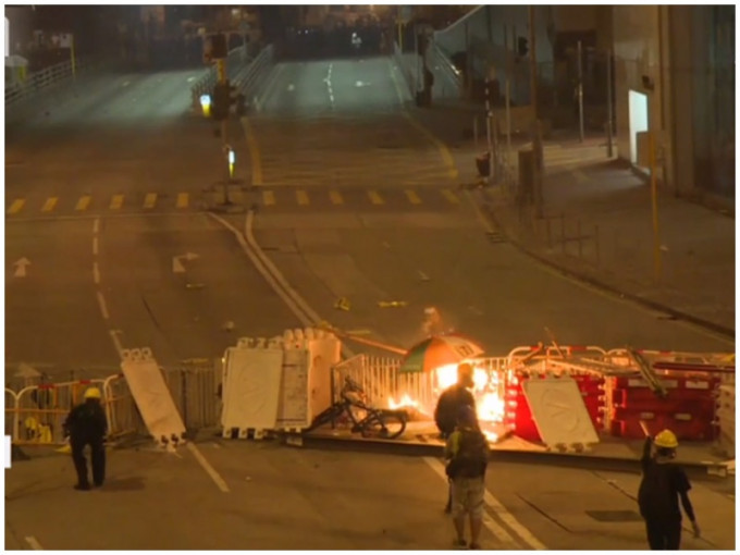 警放催淚彈後，示威者堵路縱火。有線新聞截圖