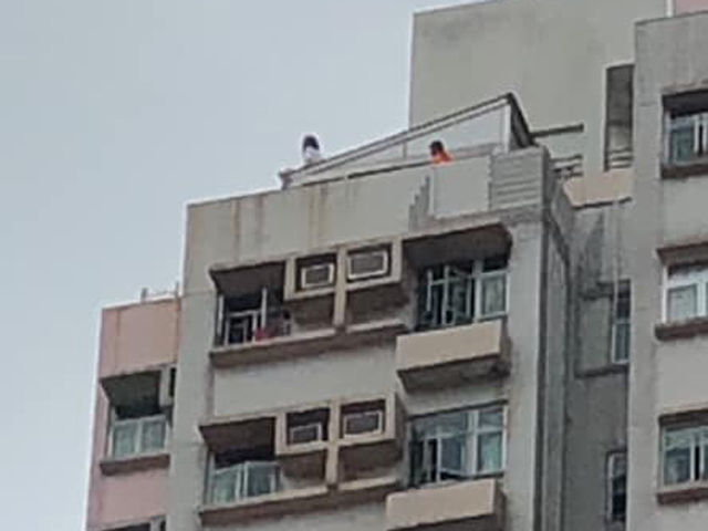 一名女子走到大廈天台危坐，企圖跳樓。 香港突發事故報料區FB/網民Kenny Wong‎圖