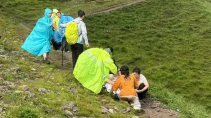 北京女驢友遭雷擊倒地後，其他路過的行山客協助急救。