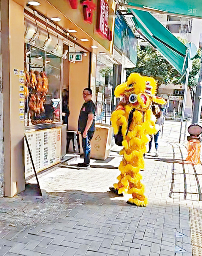 「两脚金狮」在柴湾向店铺讨利是。