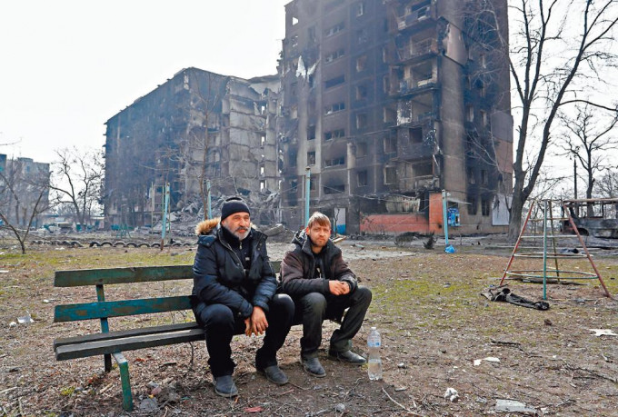 乌南部港口城市马里乌波尔多幢民宅被俄军炸毁，两名居民坐在长椅上一脸无奈。　