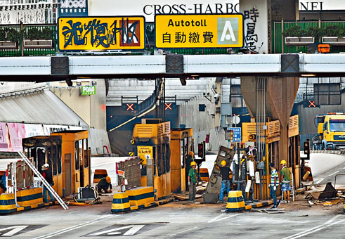 ■工程人员检视红隧收费亭损毁情况。