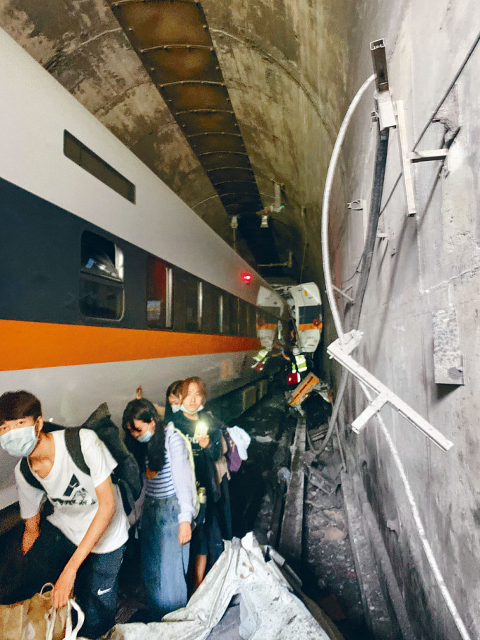 ■生還乘客帶同行李走出隧道。