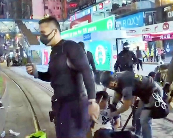 穿黑衣與示威者打扮相若的男子，疑持警棍追打示威者。