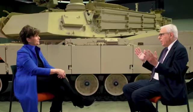 諾瓦科維奇參加電視節目錄制，背景是一輛通用動力公司製造的M1A2 SEPV3坦克。