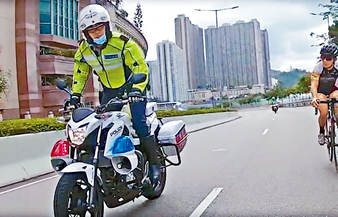 一名交通警员疑模仿单车手站立左右摇摆电单车。
