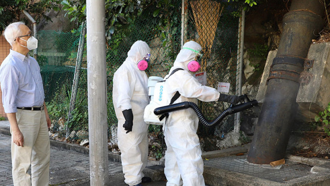 谢展寰（左）视察食环署人员以超低微量喷雾器喷洒杀虫剂。政府新闻处图片