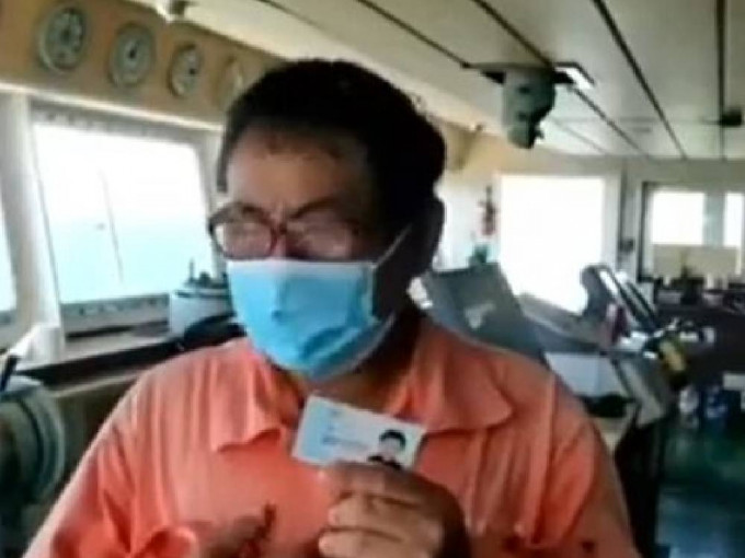 「弘进轮」一名船员手持中国身份证在互联网发短片求援。网上片段截图