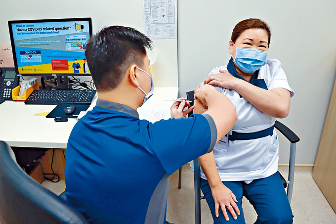 新加坡资深女护士林美云（右）周三接种辉瑞疫苗。