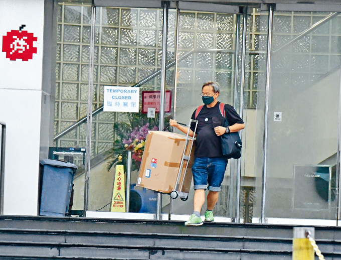 日内停运的消息传出后，《苹果日报》大楼出现有下班员工疑拿走私人物品离开。徐裕民摄