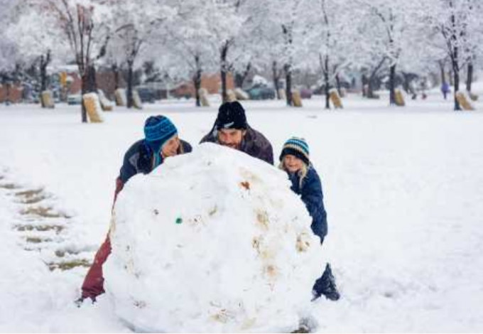 美国西北部爱达荷州博伊西市一个家庭，周一在公园滚雪球。美联社