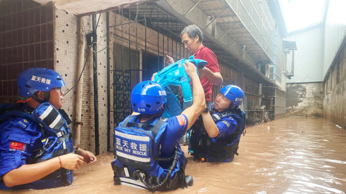 救援队队员在重庆市万州区五桥街道疏散被困居民。新华社