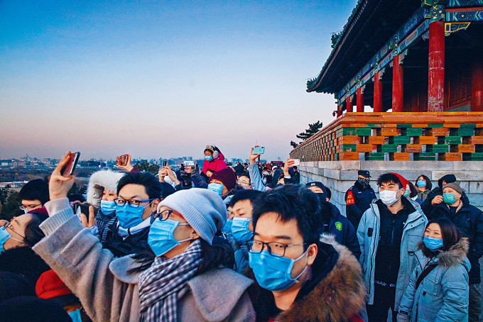 ■新冠疫情持续，北京市民昨晨戴着口罩观赏元旦日出。