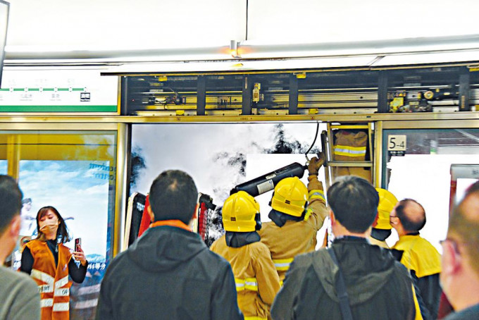 烟火扑灭后，消防员继续以灭火喷雾喷向路轨天花板位置。